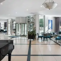Eleganckie wnętrze hotelu Radisson Blu Wrocław z fortepianem, wygodnymi fotelami i stolikami.
