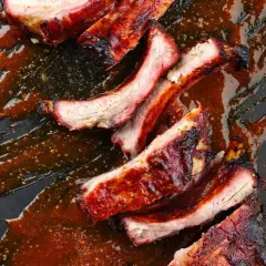 Côtelettes de porc grillées, nappées d'une sauce barbecue savoureuse. Une recette de ribs qui met l'eau à la bouche.