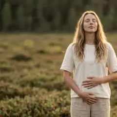 Kobieta z zamkniętymi oczami w naturze, spokojna, jakby szukała ulgi od dolegliwości, być może związanych z d-mannoza skutki uboczne.
