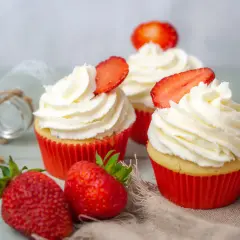Erdbeer Cupcakes mit weißer Creme und frischen Erdbeeren, dekoriert mit Erdbeerscheiben.