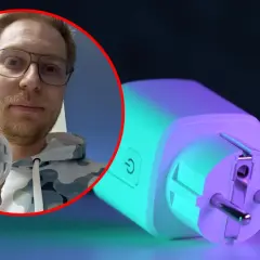 Mężczyzna pokazuje miernik energii, który pomoże Ci dowiedzieć się, jak zmniejszyć pobór prądu przez komputer.