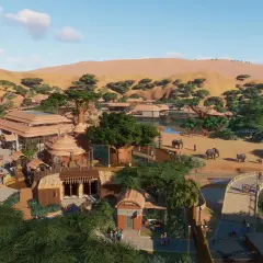 Vue aérienne d'un zoo inspiré de l'Afrique, avec des éléphants, des girafes, des bâtiments aux toits de chaume et des dunes en arrière-plan. Un exemple de configuration Planet Zoo.