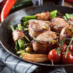 Pieczona polędwiczka wieprzowa w boczku z fasolką szparagową i pomidorkami koktajlowymi.