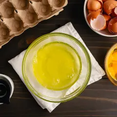Préparation pour une recette : blancs d'œufs dans un bol, jaunes d'œufs dans un autre, et coquilles dans une coupelle. Le tout prêt à être mis au frigo.