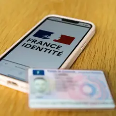 Un smartphone affiche "France Identité", à côté d'une carte d'identité physique. Le futur permis sur téléphone est en préparation.