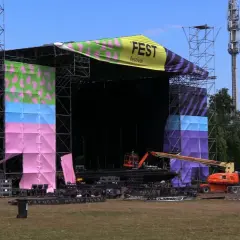 Scena festiwalowa w trakcie przygotowań. Kolorowe banery i konstrukcje zapowiadają nadchodzący fest.