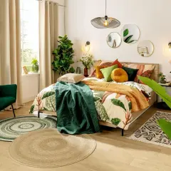 Sypialnia boho inspiracje: łóżko z pościelą w liście, zielony fotel, dywany i rośliny tworzą przytulną atmosferę.