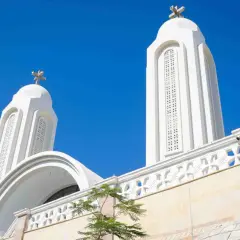 Białe wieże kościoła z krzyżami na tle błękitnego nieba. Idealna pogoda w Egipcie w sierpniu.
