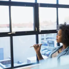 A woman ponders her future, perhaps considering a public administration degree to shape policy and improve communities.