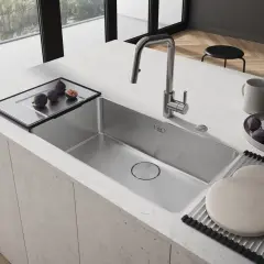 Nowoczesny zlew kuchenny ze stali nierdzewnej, z baterią i tacą z figami.
