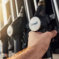 Dłoń trzymająca pistolet do tankowania z napisem "Diesel". Zastanawiasz się, jak zmniejszyć spalanie w dieslu?