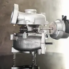 Turbocharger z siłownikiem podciśnienia na szarym tle.
