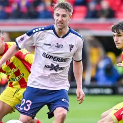 Piłkarze Górnika Zabrze i Korony Kielce walczą o piłkę. Mecz w deszczu, kibice na trybunach.