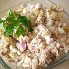 Pyszna pasta z tuńczyka i jajka, z dodatkiem ogórka kiszonego i cebuli, udekorowana natką pietruszki. Idealna na kanapki.