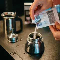 Wsypywanie proszku do czyszczenia kawiarki. Czyszczenie kawiarki sodą to świetny sposób na jej odświeżenie.