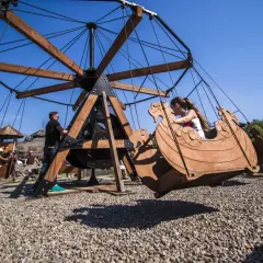 Dzieci bawią się w łódkach na karuzeli w magicznych ogrodach.