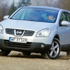 Srebrny Nissan Qashqai 2.0 benzyna na drodze szutrowej, kierowca za kierownicą.