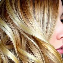 Piękne, falowane blond włosy z refleksami. Zastanawiasz się, jak często można nakładać toner na włosy, by utrzymać ten efekt?