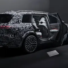 Nowy Audi Q9 w kamuflażu, z otwartymi drzwiami, prezentuje luksusowe wnętrze. Czekamy na jego cenę i premierę!