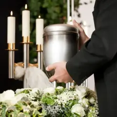 Uroczyste miejsce, gdzie można rozsypać prochy po kremacji, z urną, świecami i kwiatami.