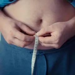 Mężczyzna mierzy obwód talii, szukając przyczyn nagłego tycia.