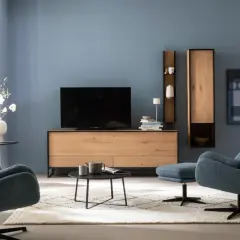 Blau passt wunderbar zu Schwarz. Ein modernes Wohnzimmer mit blauen Sesseln, einem Holzbett und schwarzem Couchtisch.