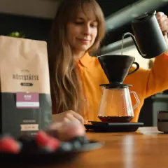 Frau brüht Kaffee. Informationen über Kaffee in der Schwangerschaft folgen.