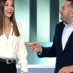 Kobieta i mężczyzna rozmawiają na scenie, mężczyzna wskazuje palcem.