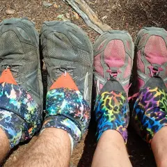Four pairs of hiking shoes with colorful gaiters. The question "do boots run bigger than shoes" is irrelevant here.