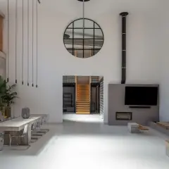 Großzügiges Loft mit Betonwänden, Stahlfenstern und einer Treppe. Der Stil ist **industrial chic**, mit Pflanzen und einer gemütlichen Sitzecke.