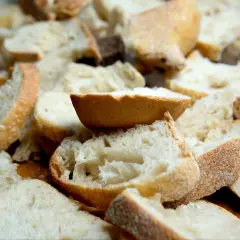 Kawałki czerstwego chleba pokrojone w kostkę i plastry, gotowe do zapiekanki.