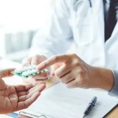 Lekarz podaje pacjentowi tabletki. Ważne jest, by wiedzieć, po jakim czasie działa antybiotyk, aby skutecznie leczyć infekcję.