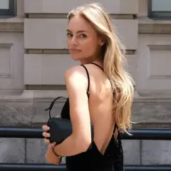 Blondynka w czarnej sukience bez pleców, idealna stylizacja. Zastanawiasz się, jaki biustonosz do sukienki bez pleców? Ten model jest doskonałym przykładem.