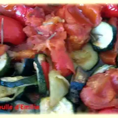 Un plat coloré de ratatouille au four, avec des rondelles de courgettes, des poivrons rouges et des tomates. Un délice provençal !