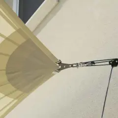 Zapięcie żagla przeciwsłonecznego do ściany za pomocą systemu lin i karabińczyków.