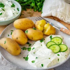 Kleine, gekochte Kartoffeln mit Kräuterquark und Gurkenscheiben – ein einfaches Gericht, das zeigt, wie vielseitig Rezepte mit Kartoffeln als Hauptspeise sein können.