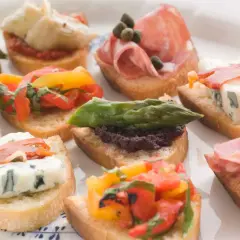 Variedad de crostini italiano: con salami, queso azul, espárragos, tomates y aceitunas.