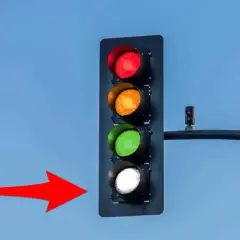 Un feu de circulation avec les lumières rouge, orange et verte allumées, et la lumière blanche clignotante. Une flèche rouge pointe vers le feu.
