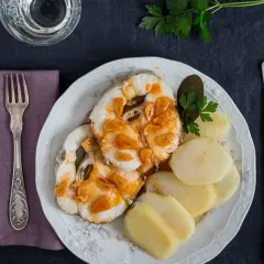 Merluza a la gallega con patatas cocidas, ajo dorado y perejil. Un plato tradicional listo para disfrutar.