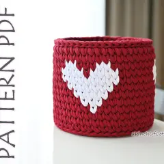 Cestino uncinetto rosso con cuori bianchi, perfetto per decorare la casa o come idea regalo.