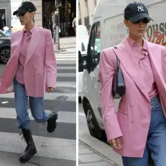 Kobieta w marynarce w odcieniu **magenta kolor** i jeansach idzie ulicą.