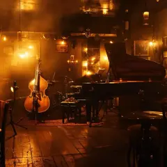 Atmosfera jazz a Milano, con contrabbasso, pianoforte e batteria pronti per eventi musicali.