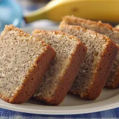 Fredriks fika: saftig banankaka i skivor på en vit tallrik, med en banan i bakgrunden.