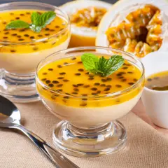 Douceur tropicale : deux coupes de mousse onctueuse, garnies de fruits de la passion et de menthe, un délice de dessert brésilien.