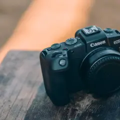 Czarny aparat Canon EOS RP leży na drewnianym blacie. Idealny do canon rp testów.