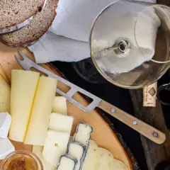 Deska serów z chlebem i kieliszkiem wina, idealna do degustacji Bardolino Chiaretto.