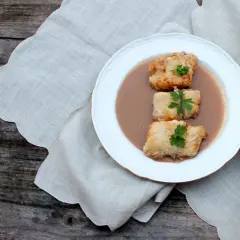 Tres trozos de bacalao rebozado en una salsa cremosa, decorados con perejil. Una de las muchas deliciosas recetas de bacalao.