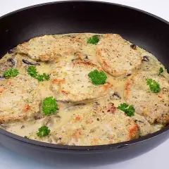 Schab w sosie pieczarkowym, podany w głębokiej patelni, ozdobiony natką pietruszki. Aromatyczny i sycący obiad.