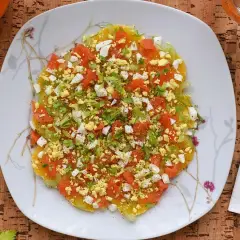 Deliciosa ensalada de invierno con rodajas de naranja, tomate picado, huevo duro y perejil fresco.