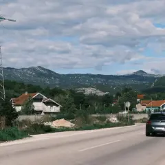 Szukasz pomysłu, gdzie jechać w niedzielę? Śląsk oferuje malownicze krajobrazy, domy i góry. Samochód jedzie drogą wśród zieleni.